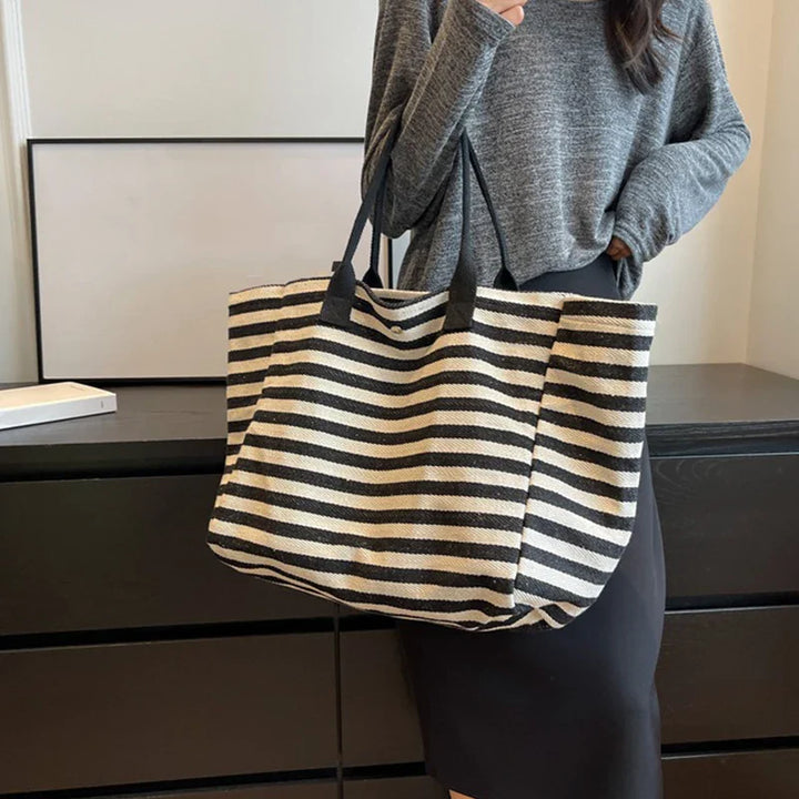 Accessoire de mode féminin: sac cabas de plage marinière XL en toile rayée noire, chic et pratique.