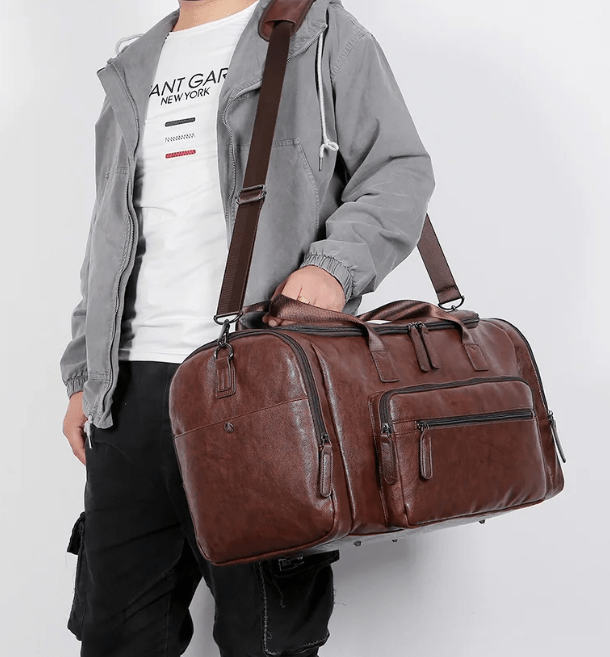 Sac de voyage en cuir vegan marron, adapté pour homme, avec multiples poches de rangement.