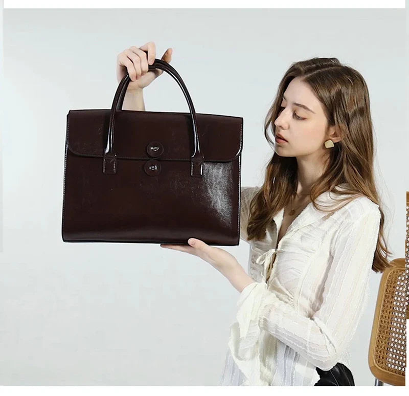 Sac de travail femme Antonella en cuir camel, posé sur une chaise, prêt pour un déplacement professionnel.