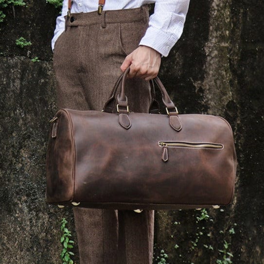 Gros plan sur les poignées en cuir du sac de voyage homme, confortables et durables