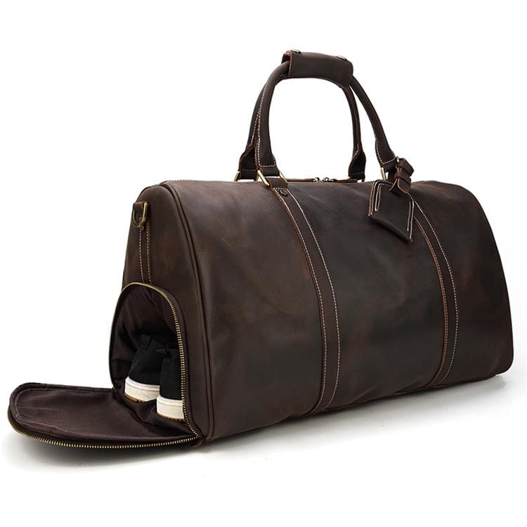 Image détaillée d'un sac de voyage homme en cuir grainé, montrant les coutures et la texture luxe.