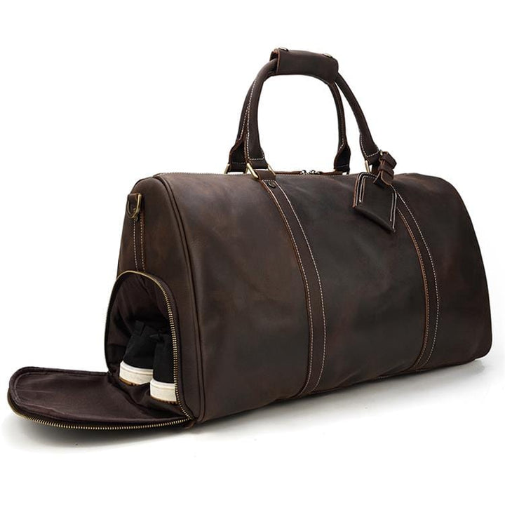 Image détaillée d'un sac de voyage homme en cuir grainé, montrant les coutures et la texture luxe.