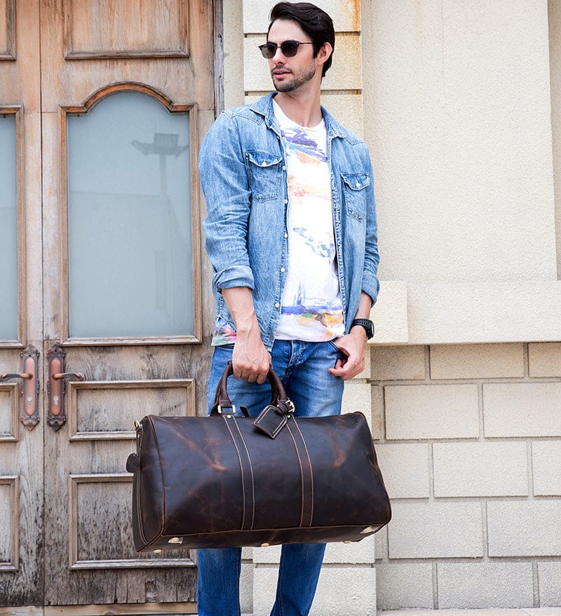 Gros plan sur la fermeture éclair en métal d'un sac voyage homme en cuir, symbolisant la durabilité.