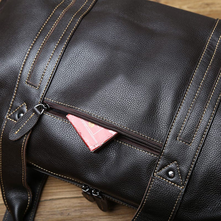 Gros plan sur la texture du cuir véritable du sac de voyage homme, qualité supérieure et élégance.