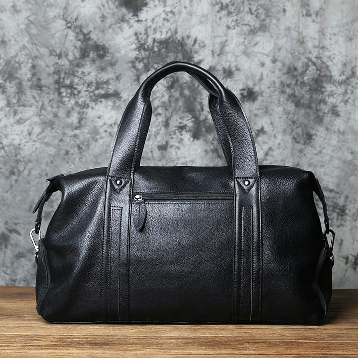 Sac de voyage homme, modèle élégant en cuir noir, parfait pour les déplacements professionnels ou loisirs.