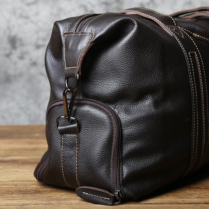 Vue intérieure d'un sac de voyage homme en cuir noir, compartiments spacieux pour affaires.
