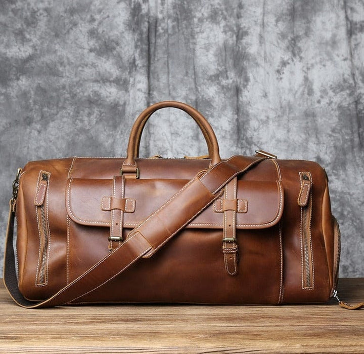 Sac de voyage en cuir pour homme, en bandoulière sur épaule, accessoire voyage stylé.