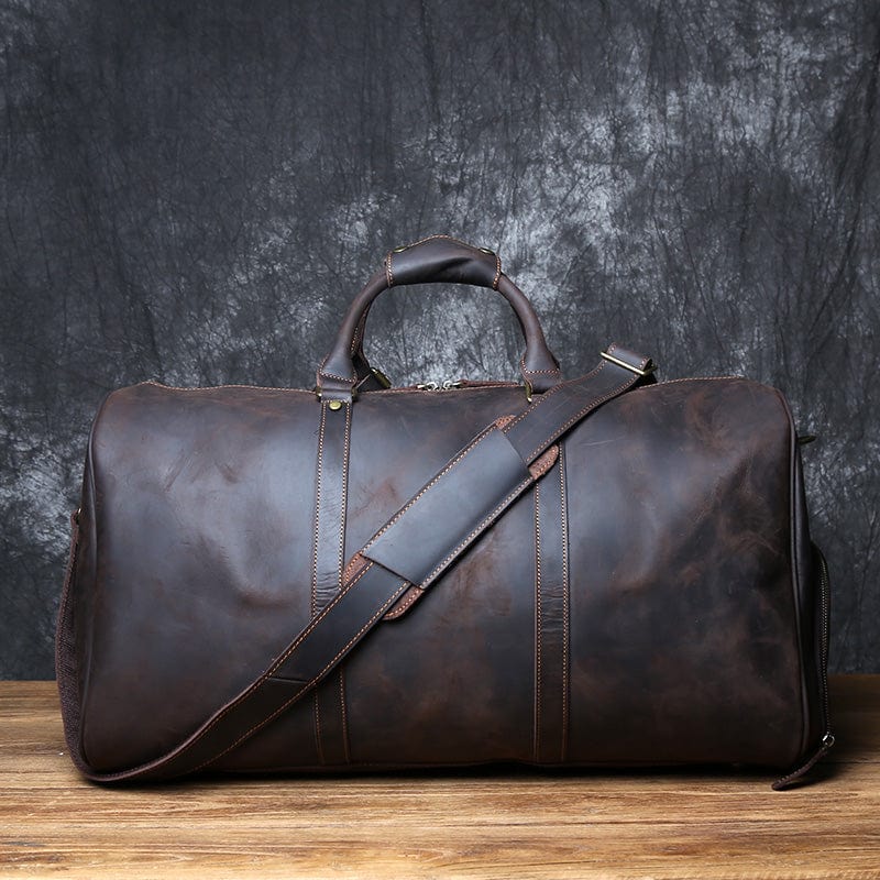 Sac de voyage en cuir marron foncé pour homme, style baroudeur et intemporel, sur le sol
