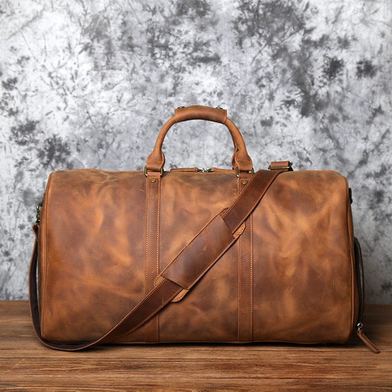 Gros plan d'un sac de voyage homme en cuir, texture du cuir véritable et finitions détaillées