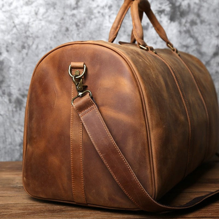 Homme tenant un sac de voyage week-end en cuir véritable, prêt pour l'aventure