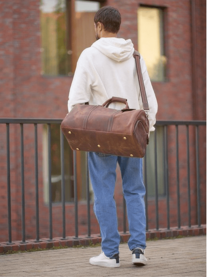 Sac de voyage cuir pour homme sur fond blanc, mettant en valeur sa texture et sa couleur riche
