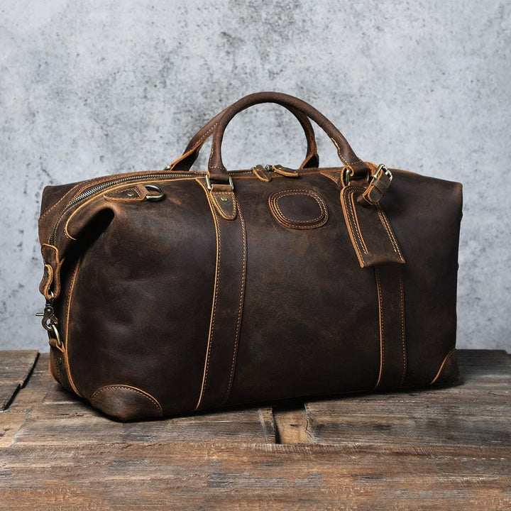 Accessoire homme: grand sac de voyage en cuir souple avec bandoulière détachable, style rétro.