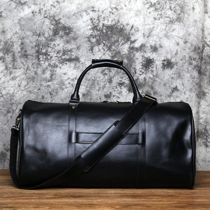 Gros plan sur la boucle métallique et le tag en cuir d'un sac de voyage pour homme