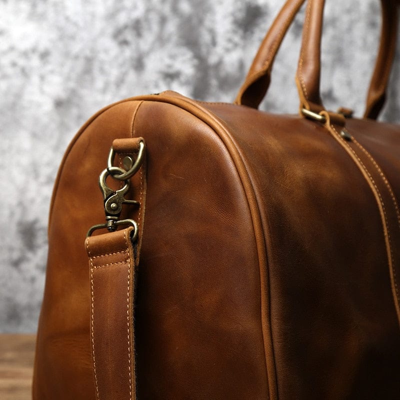 Détail du cuir pleine fleur d'un sac de voyage homme, texture riche et durable