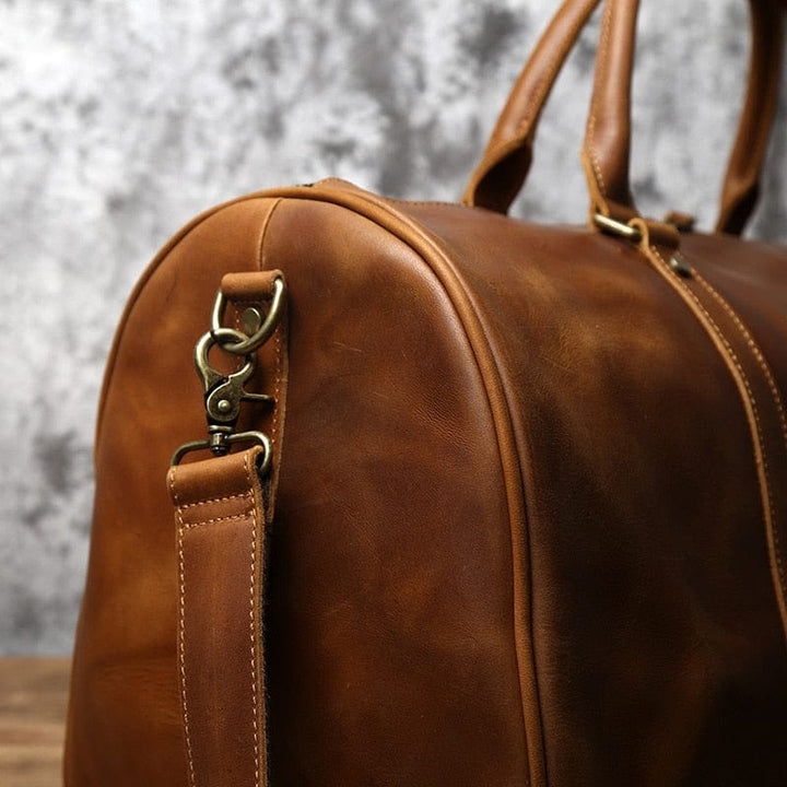 Détail du cuir pleine fleur d'un sac de voyage homme, texture riche et durable