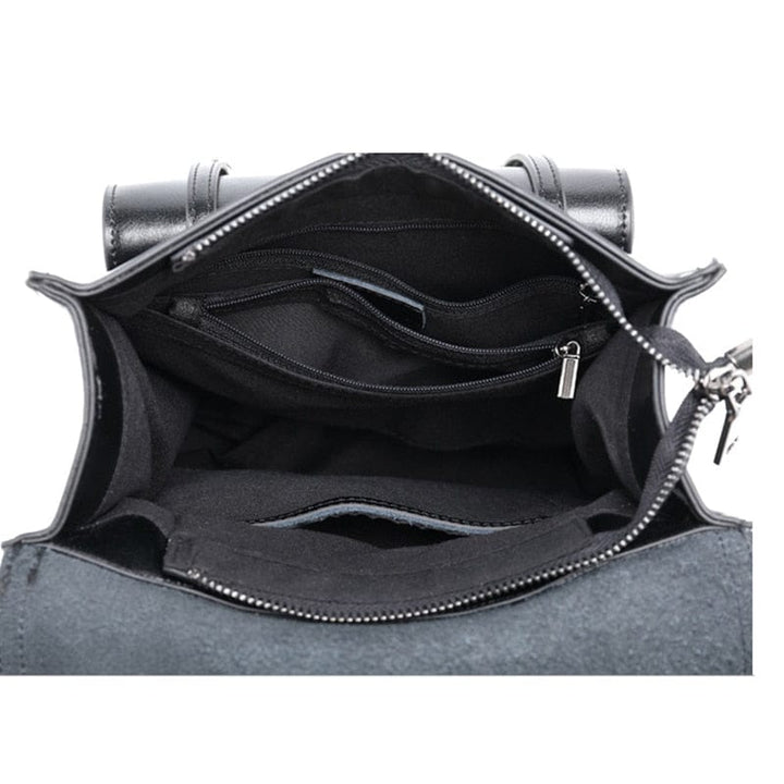 Sac à dos en cuir pour femme posé sur une table, accessoires en métal doré, style élégant et féminin