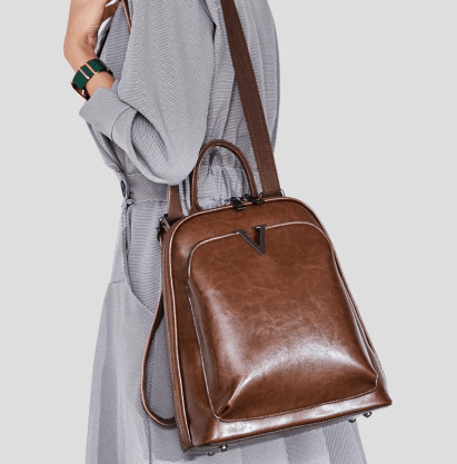 Sac à dos femme Alba couleur café, en cuir verni, posé sur une surface, mettant en valeur sa texture brillante.