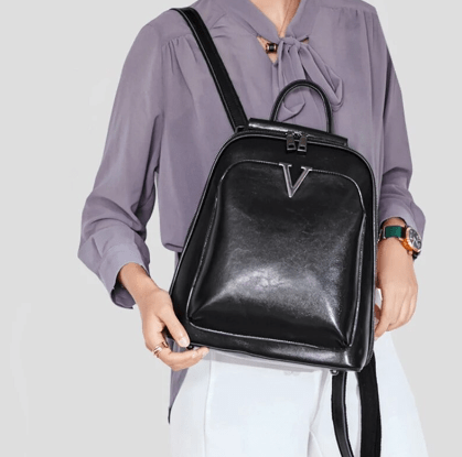 Modèle portant le sac à dos Alba en cuir verni noir, démontrant sa taille idéale pour un usage quotidien en ville.