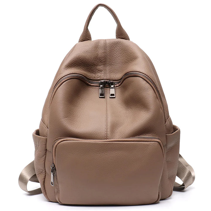 Sac à dos urbain pour femme, en cuir vegan marron, avec compartiment principal et poches latérales pratiques.