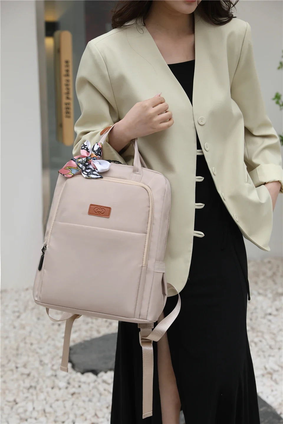 Femme portant un sac à dos élégant en ville, accessoire chic pour ordinateur portable 13 pouces, style urbain.