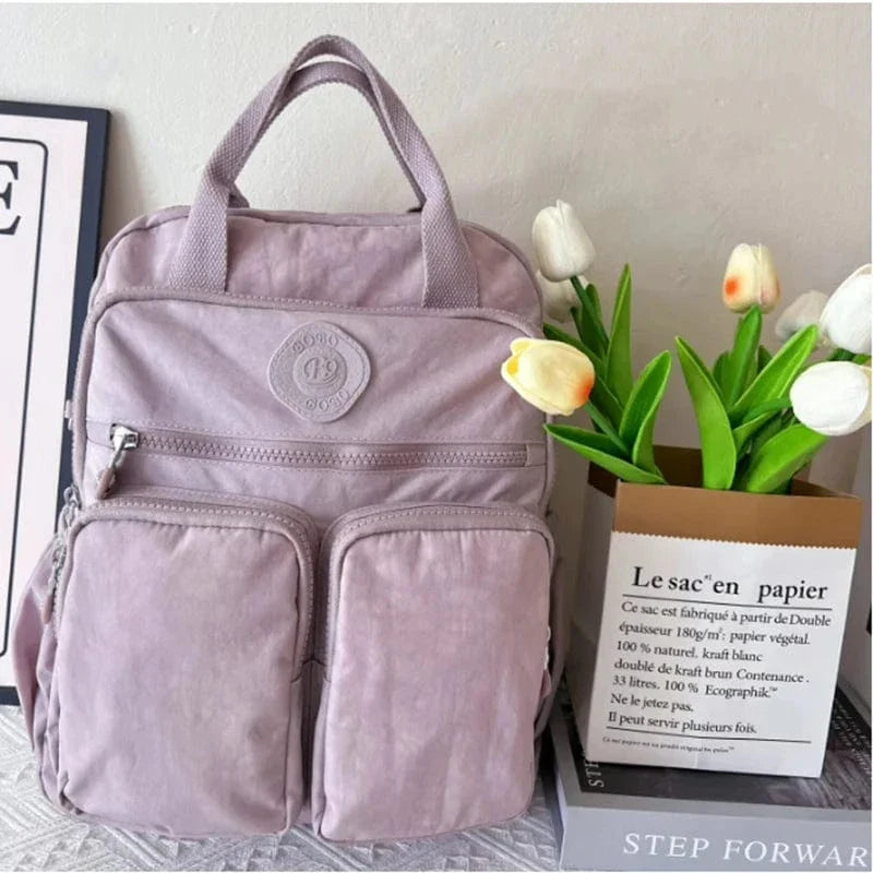 Sac à dos femme avec poche avant zippée, facile d'accès, idéale pour les fournitures de collège ou d'école.