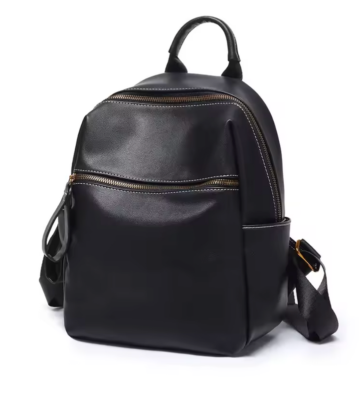 Détail de la fermeture éclair métallique et des coutures soignées d'un sac à dos élégant en cuir noir pour femme.