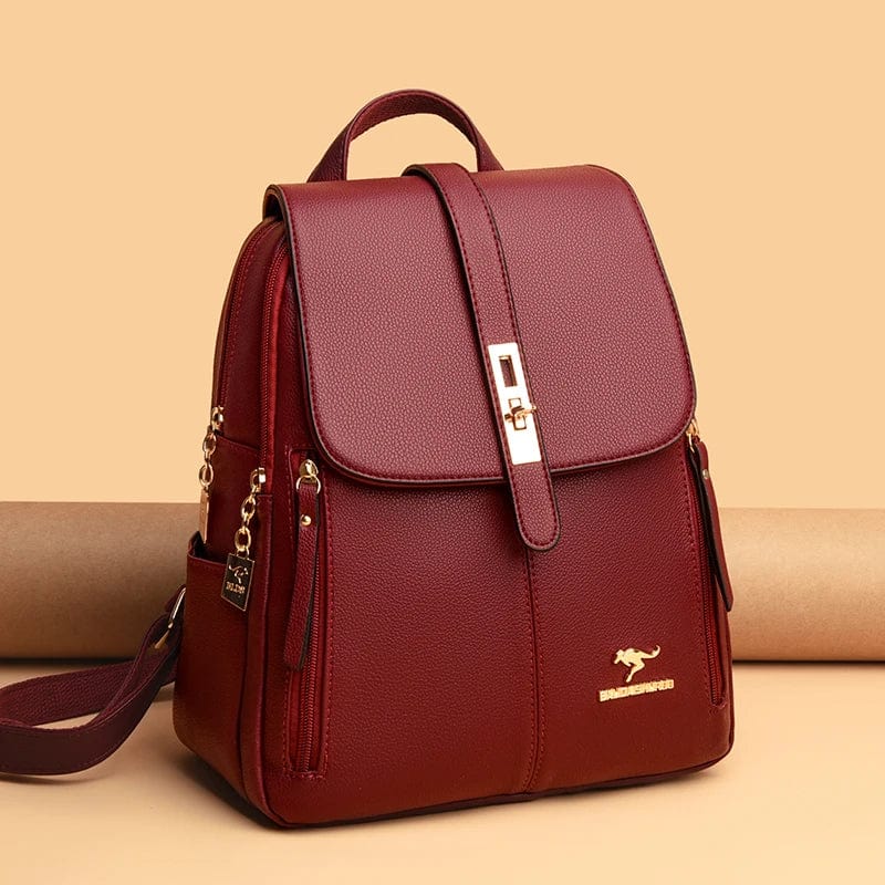 Gros plan d'un sac à dos élégant rouge pour femme, mettant en avant la texture du cuir vegan et les détails dorés.