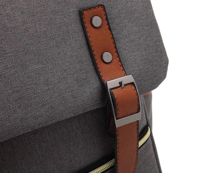 Vue de côté d'un sac à dos vintage gris, compatible PC portable, idéal pour les déplacements