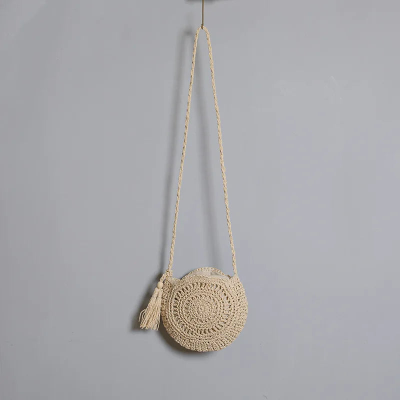 Sac bandoulière en paille bohème porté, parfait pour la plage, les vacances et un look d'été chic.