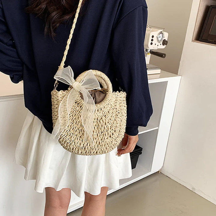 Sac femme rond en paille naturelle, idéal pour la plage ou les sorties estivales.