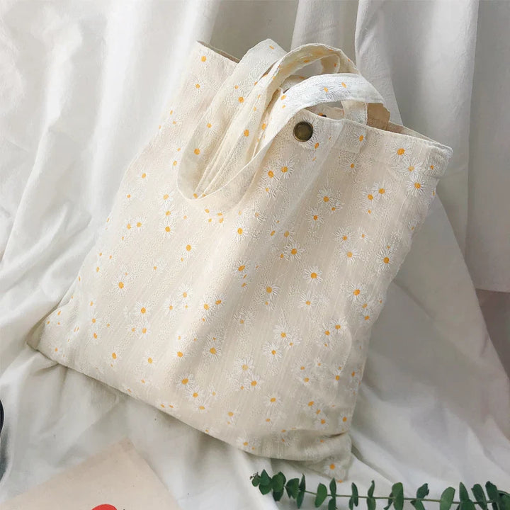 Sac fourre-tout fleuri élégant en toile pour femme, idéal shopping. Motif floral printanier coloré, chic et pratique.