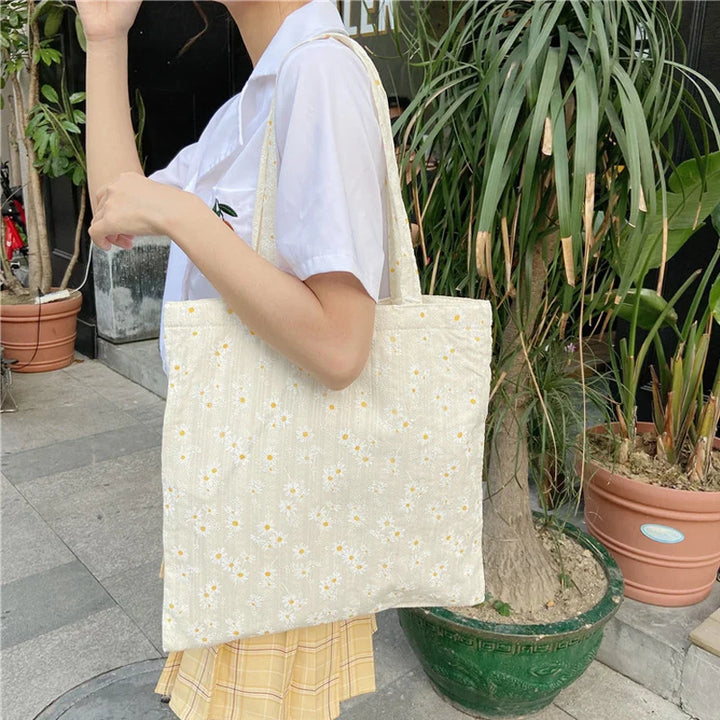 Sac à main fourre-tout fleuri en toile pour femme. Design printanier chic avec motifs floraux vifs, parfait pour le quotidien.