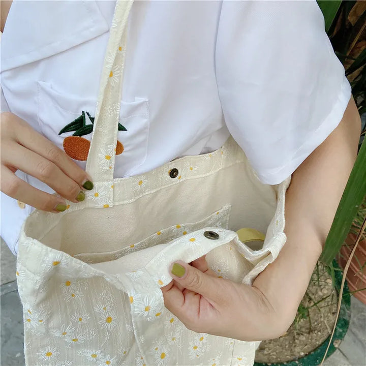 Accessoire de mode femme: sac fourre-tout fleuri en toile. Style printanier élégant, idéal pour le shopping ou les sorties décontractées.