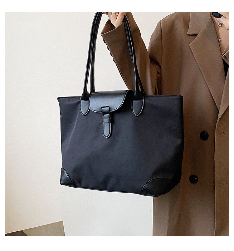 Sac noir spacieux pour femme, design épuré, excellent pour transporter essentiels, un vrai must-have