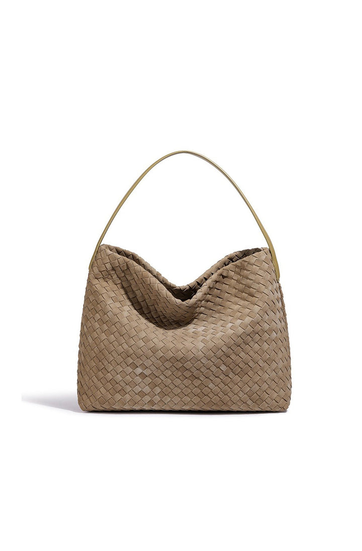 Femme en déplacement avec un grand sac fourre-tout tressé élégant. Idéal pour un usage quotidien stylé.