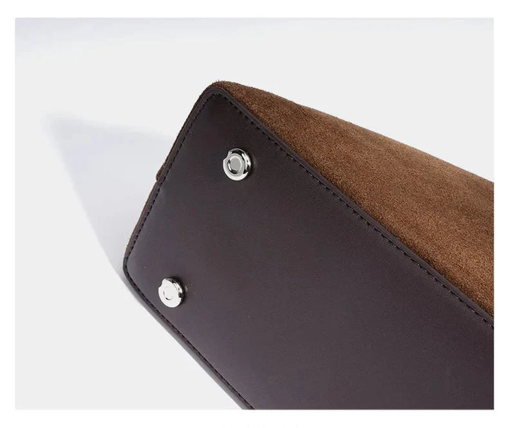 Sac à main Alma en cuir suédé marron sur fond neutre, met en valeur sa couleur automnale