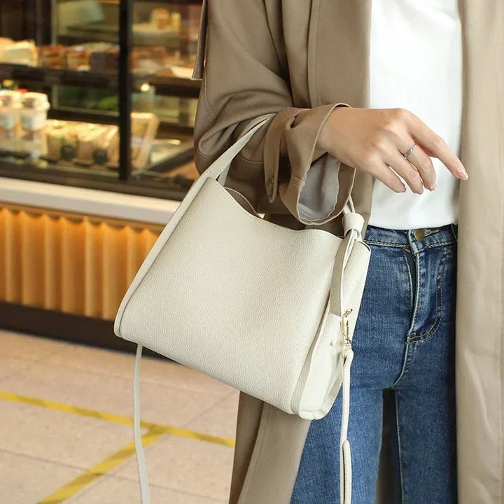 Mode: sac à main Astride bordeaux en cuir grainé, posé sur une table pour montrer son volume