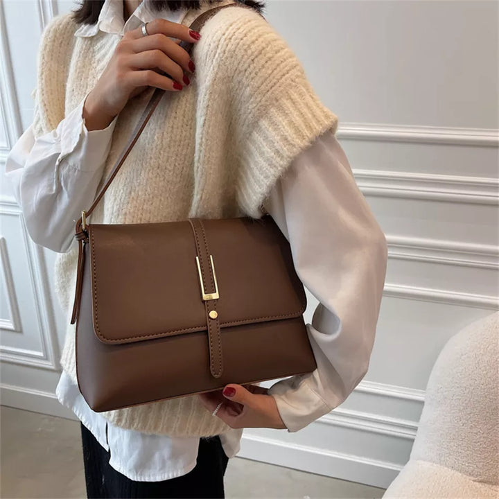 Sac à main bandoulière femme noir élégant en cuir synthétique, style moderne.