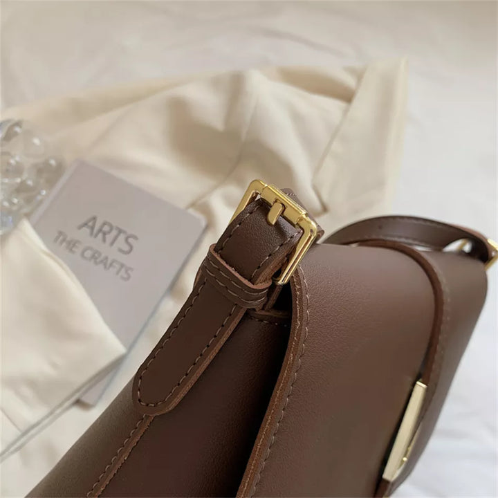 Sac femme noir élégant, porté en bandoulière, idéal pour une allure chic moderne.