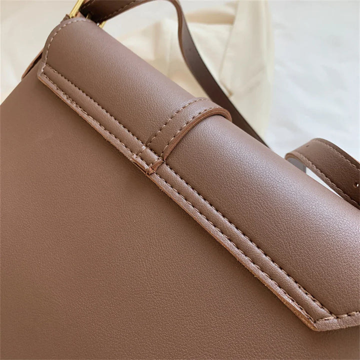 Sac femme noir en bandoulière, détail de la texture en cuir synthétique.