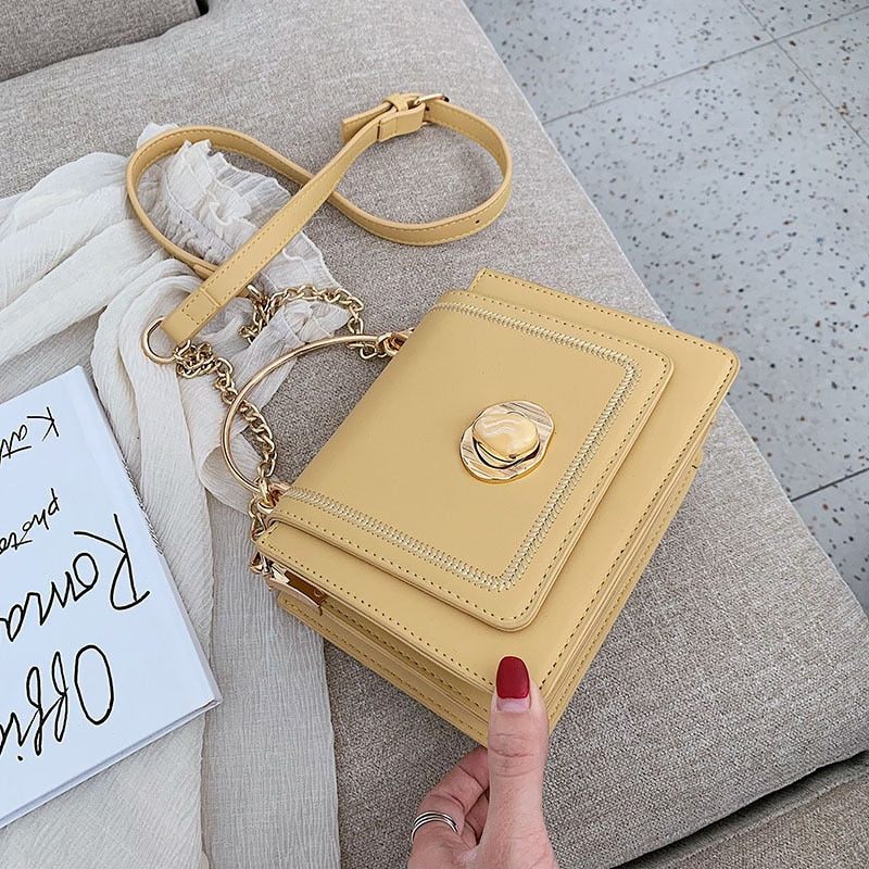 Vue de face du sac à main Giulia, bandoulière chaîne dorée, en cuir noir, petite maroquinerie chic