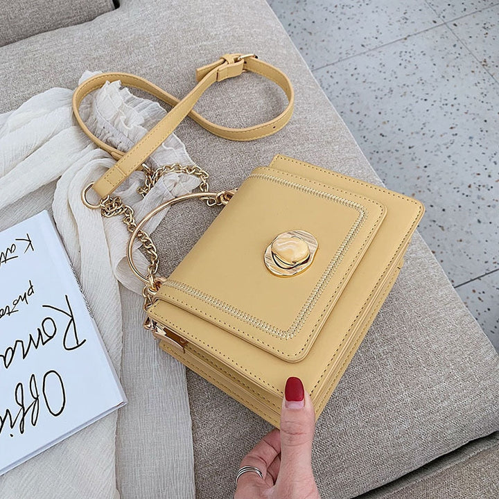 Vue de face du sac à main Giulia, bandoulière chaîne dorée, en cuir noir, petite maroquinerie chic