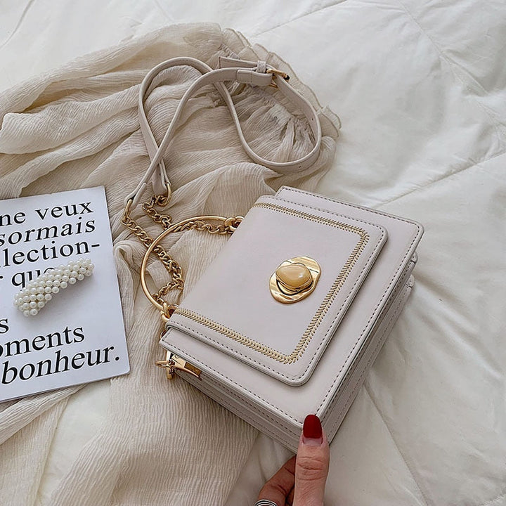 Détail de la chaîne dorée et du fermoir sur le sac à main Giulia, accessoire mode femme