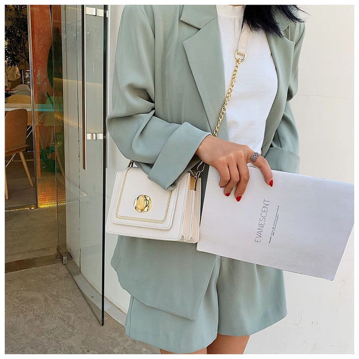 Photo d'un sac Giulia, bandoulière chaîne, posé sur une surface, montrant sa texture cuir