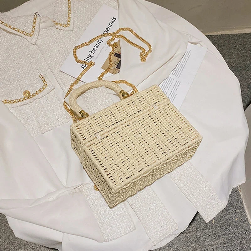 Sac bandoulière carré en paille artisanale beige, idéal pour un look d'été vintage.