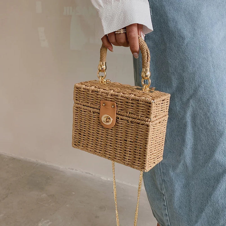 Sac d'épaule femme en paille tressée, forme carrée élégante, finition chic et estivale.