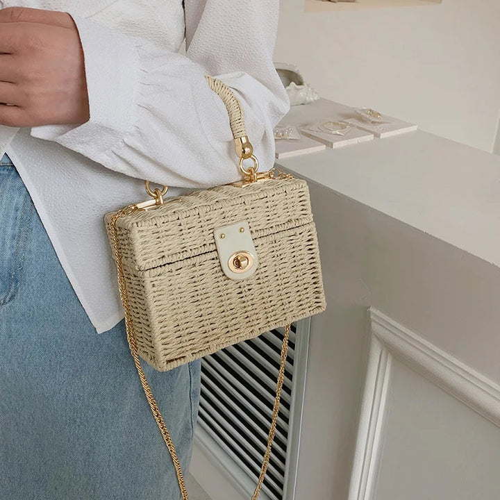 Détail d'un sac carré en paille tressée, texture naturelle et artisanale, couleur beige estivale.