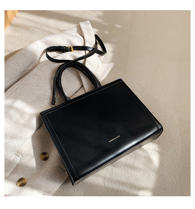 Sac femme noir de forme carrée, au design élégant, parfait pour accessoiriser une tenue mode ou de bureau.