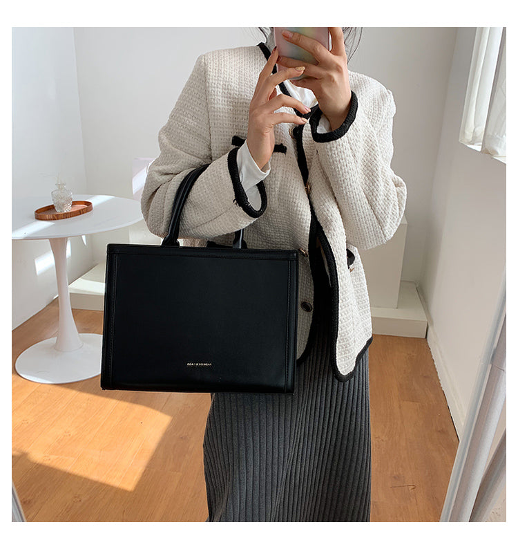 Élégant sac bandoulière carré noir, en cuir synthétique, un accessoire mode essentiel pour toute femme active.