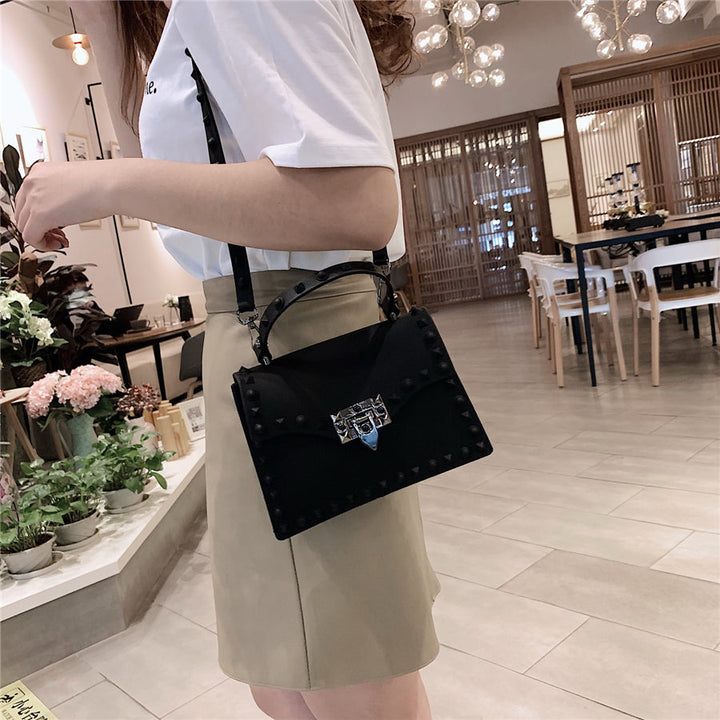 Gros plan d'un sac cartable noir pour femme, texture similicuir, fermoir argenté brillant, mode